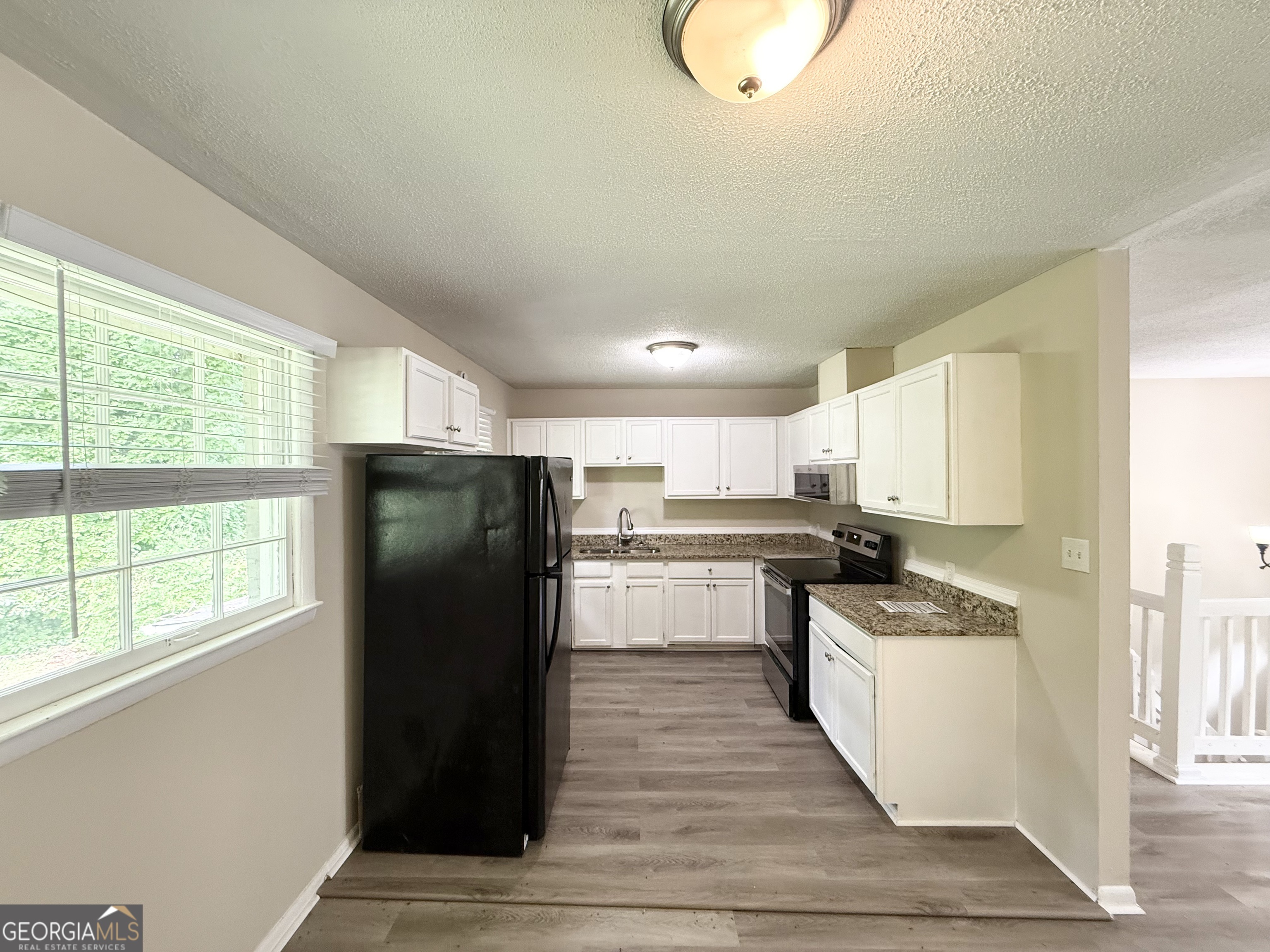 2782 Ocean Valley Road Atlanta, GA 30349 - Photo 8 of 27 a kitchen with stainless steel appliances granite countertop a refrigerator a sink and a stove with wooden floor
