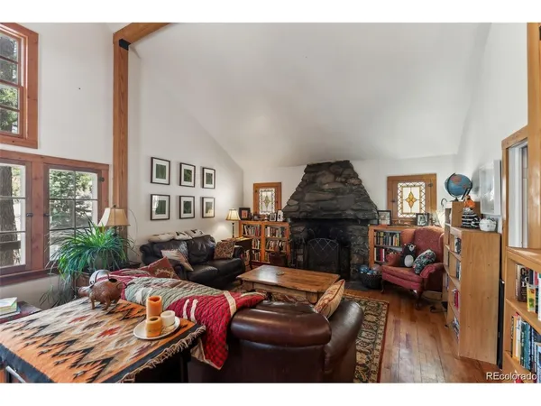a living room with furniture a bookshelf and a window