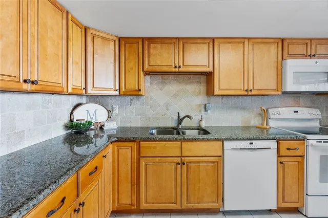 a kitchen with stainless steel appliances granite countertop a sink a stove and cabinets