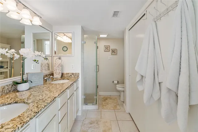 a spacious bathroom with a granite countertop sink a toilet and shower