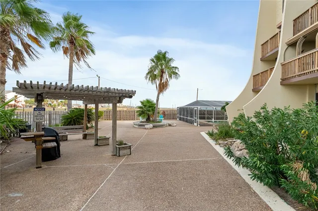 a view of a patio with a table and chairs under an umbrella