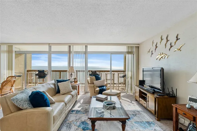 a living room with furniture a large window and a flat screen tv