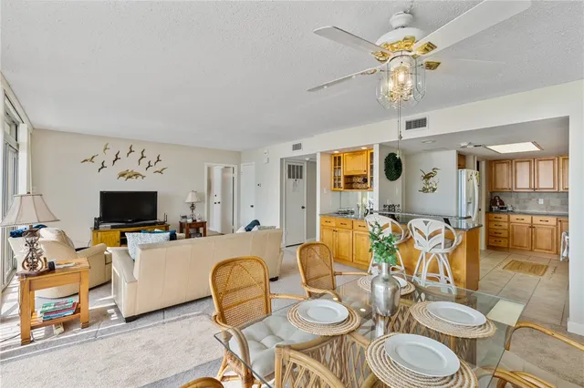 a dining room with furniture a chandelier and a flat screen tv