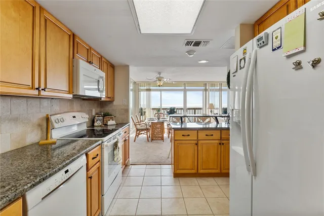 a kitchen with stainless steel appliances granite countertop a stove a sink and a refrigerator