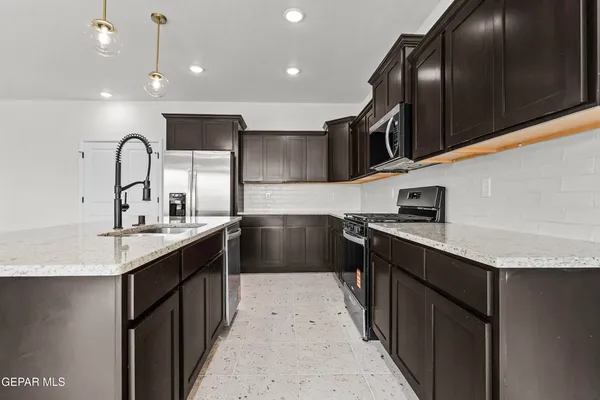 a kitchen with stainless steel appliances granite countertop a sink stove and cabinets