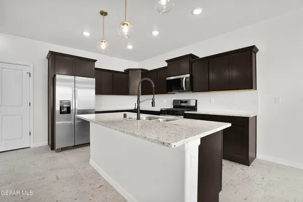 a kitchen with stainless steel appliances granite countertop a sink a stove and a refrigerator