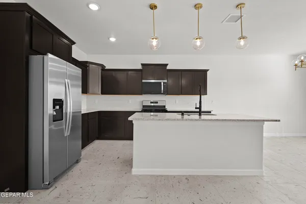 a kitchen with stainless steel appliances granite countertop a refrigerator a sink and a stove