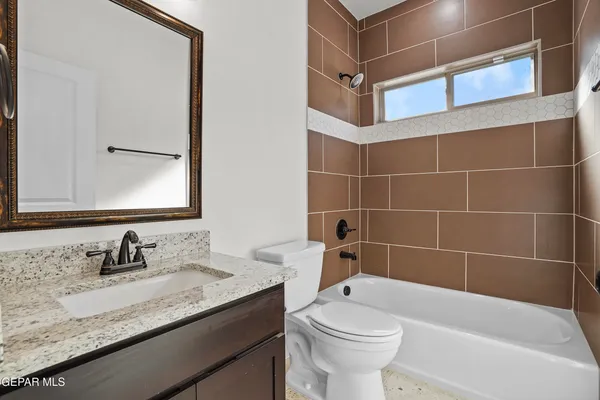 a bathroom with a granite countertop sink a toilet and mirror