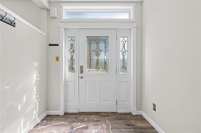 a view of a hallway with wooden floor and a bathroom