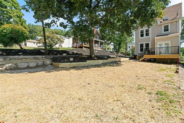 a view of a house with a yard and potted plants