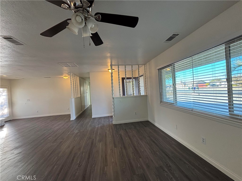 15137 Luna Road Victorville, CA 92392 - Photo 5 of 20 a view of an empty room with wooden floor and a window
