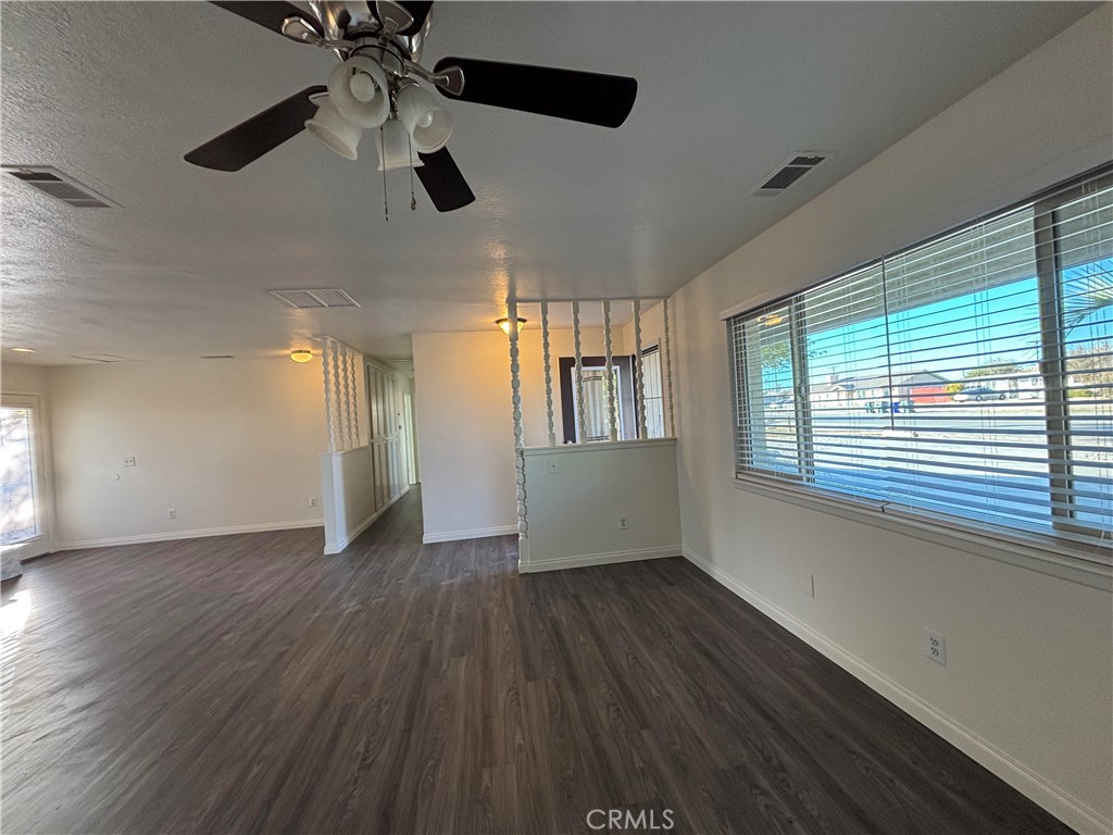 15137 Luna Road Victorville, CA 92392 - Photo 7 of 20 a view of an empty room with wooden floor and a window