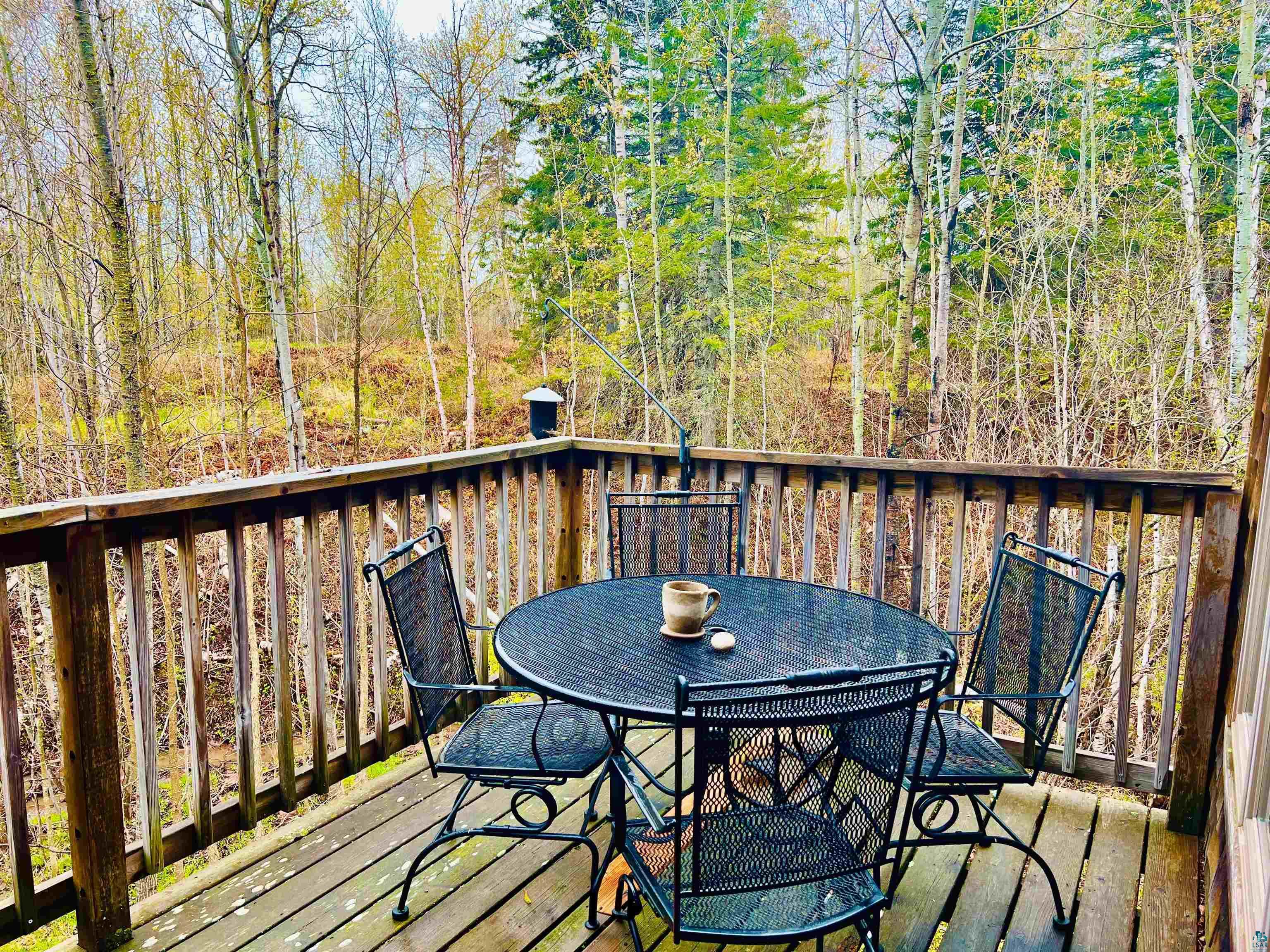 67 Snowshoe Trail Tofte, MN 55615 - Photo 17 of 42 Wood deck featuring vertical wood railing, surrounded by mature trees and natural foliage