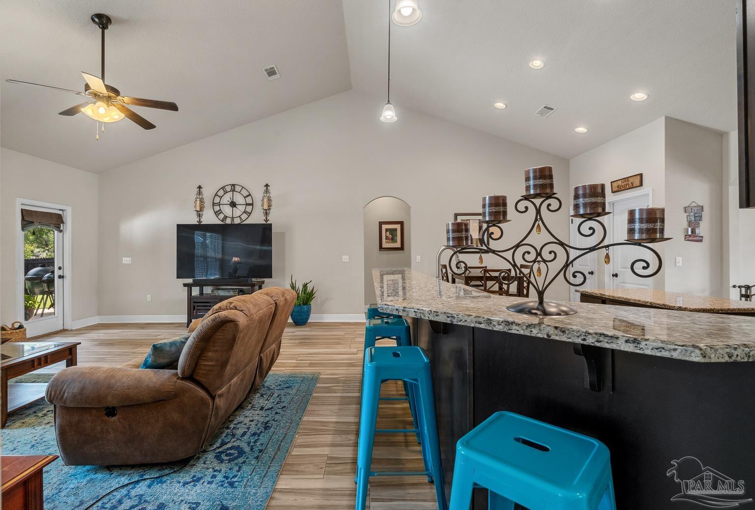 5606 Prairie Meadows Court Pace, FL 32571 - Photo 13 of 62 a living room with furniture a flat screen tv and kitchen view