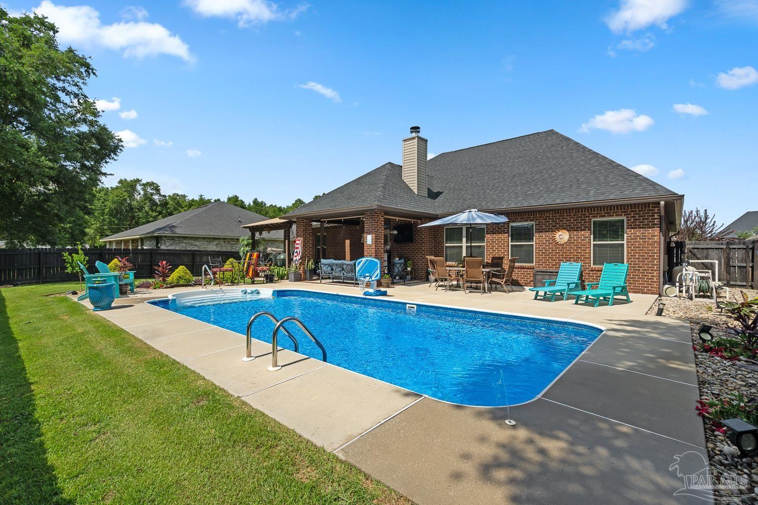 5606 Prairie Meadows Court Pace, FL 32571 - Photo 6 of 62 a view of a house with pool and chairs