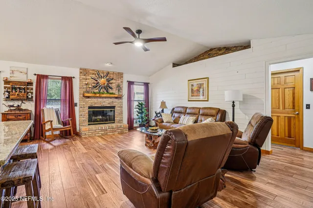 a living room with furniture a flat screen tv and a fireplace