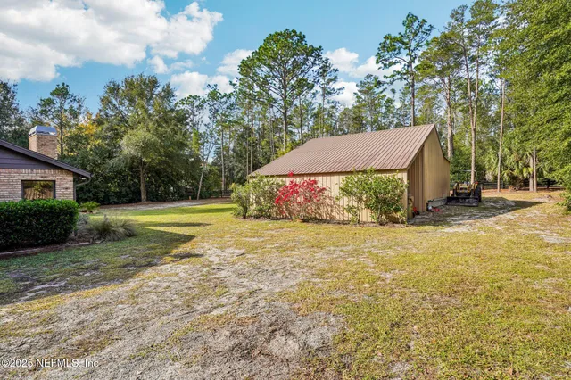 a view of a house with a yard and tree s