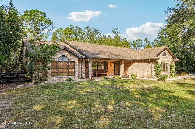 a front view of a house with a garden and trees