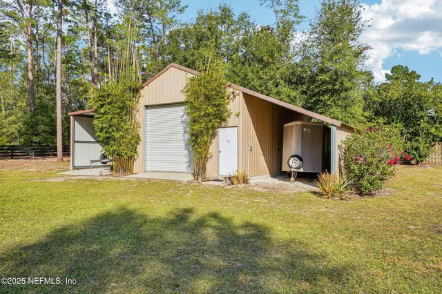a view of a house with backyard and trees