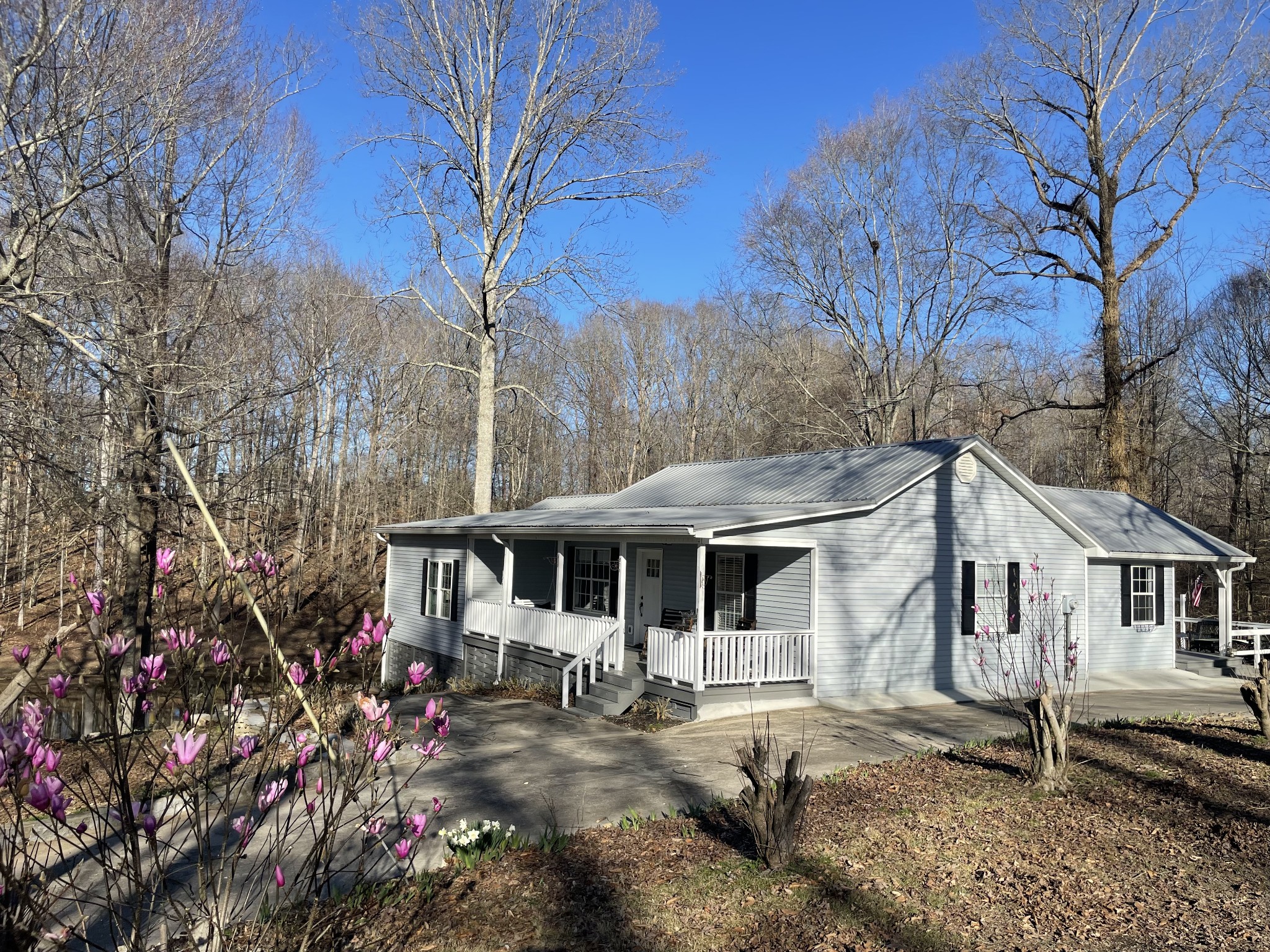 310 Shasteen Ridge Road Lynchburg, TN 37352 - Photo 8 of 36 a view of a white house with a large tree next to a yard