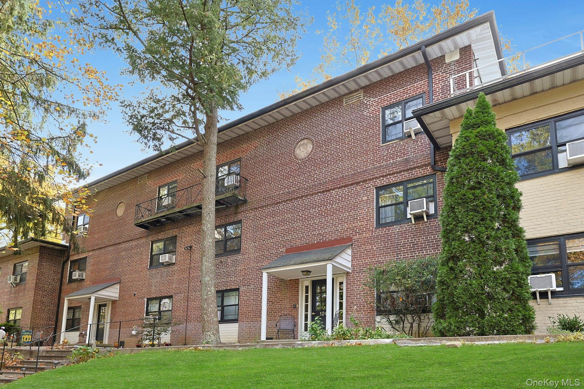 1245 California Road, Unit B23 Eastchester, NY 10709 - Photo 17 of 21 front view of a brick house with a yard