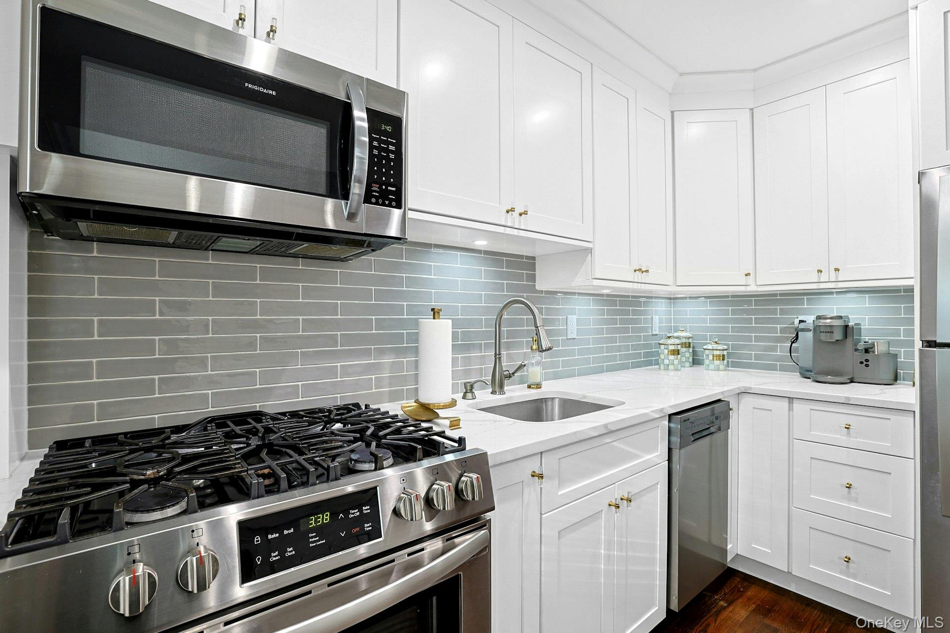 1245 California Road, Unit B23 Eastchester, NY 10709 - Photo 5 of 21 a kitchen with stainless steel appliances a stove a microwave sink and cabinets
