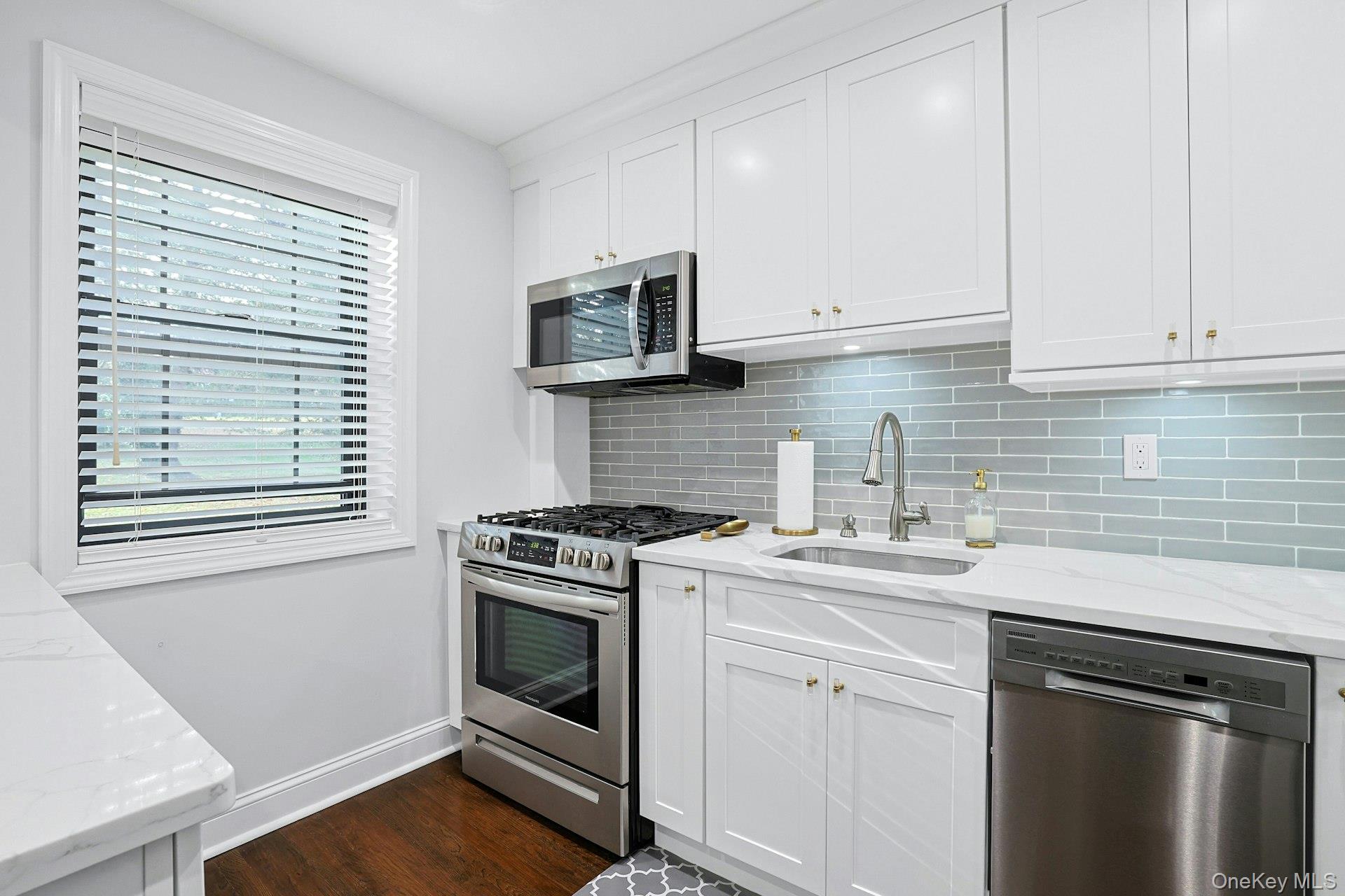 1245 California Road, Unit B23 Eastchester, NY 10709 - Photo 6 of 21 a kitchen with white cabinets and appliances