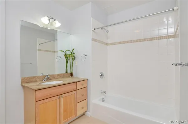 a bathroom with a granite countertop sink a mirror and a bathtub