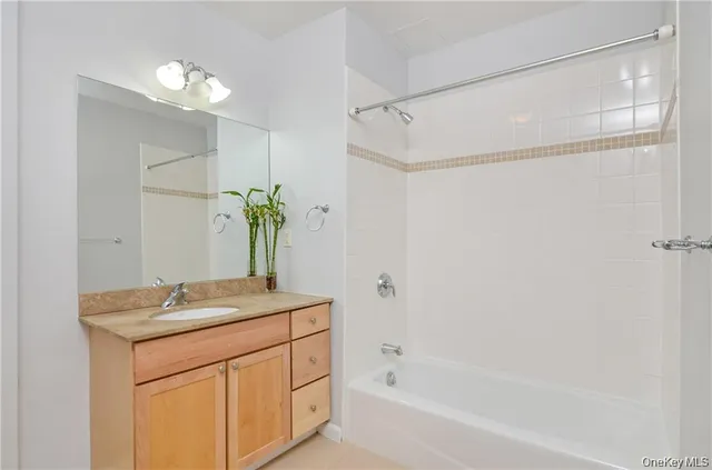 a bathroom with a granite countertop sink a mirror and a bathtub