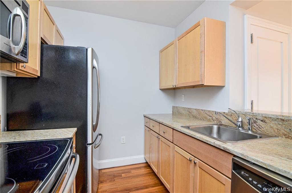 543 Main Street, Unit 402 New Rochelle, NY 10801 - Photo 7 of 21 Kitchen featuring light brown cabinets, stainless steel appliances, light wood-type flooring, and light stone countertops