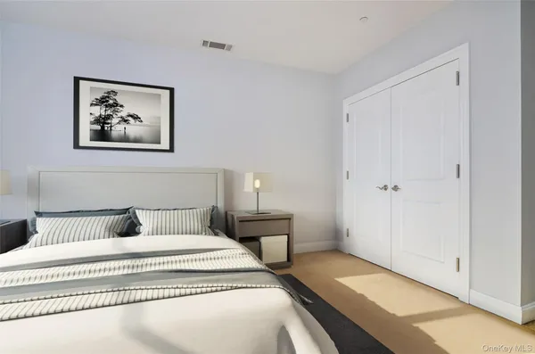 a bedroom with a bed and painting on the wall