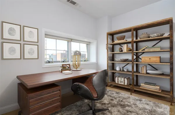 a view of a workspace with furniture and a window