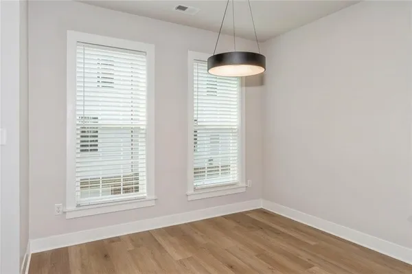 a view of an empty room with a window and a chandelier