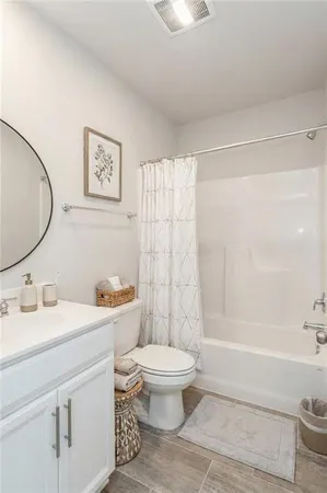 a bathroom with a white toilet sitting next to a bathroom sink and a shower