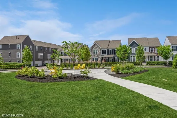 a front view of a house with a garden and sitting area