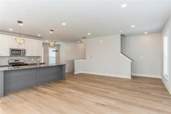 a large kitchen with stainless steel appliances kitchen island a large counter top and a sink