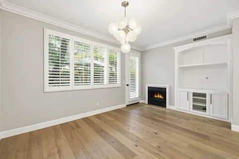 a view of an empty room with a window and fireplace