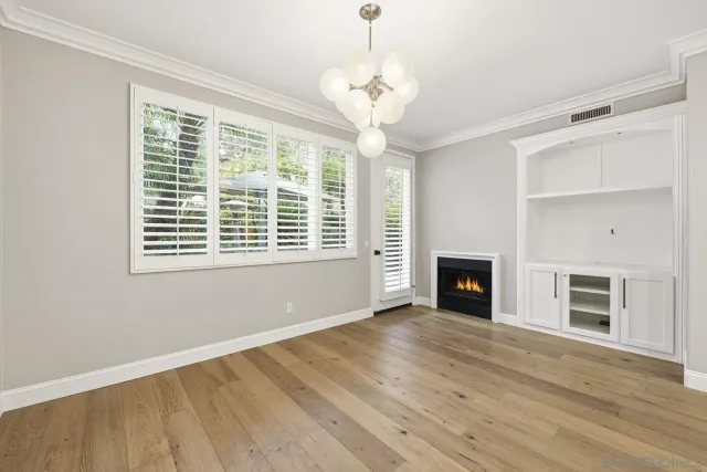 a view of an empty room with a window and fireplace