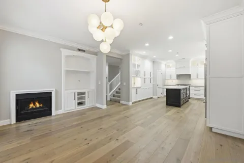 a view of a kitchen with a stove wooden cabinets and a fireplace