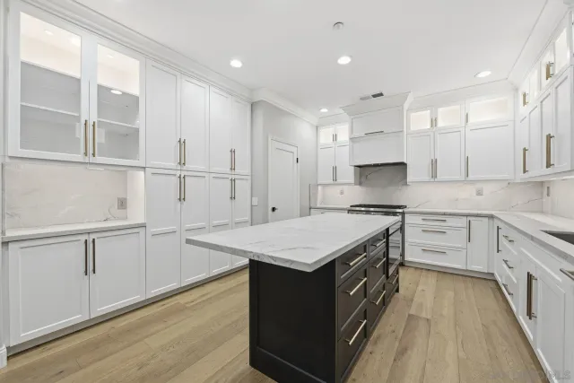 a kitchen with kitchen island white cabinets and wooden floor