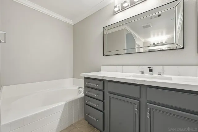 a bathroom with a tub sink and mirror