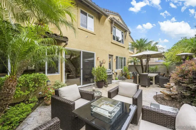 a view of a patio with couches table and chairs and potted plants