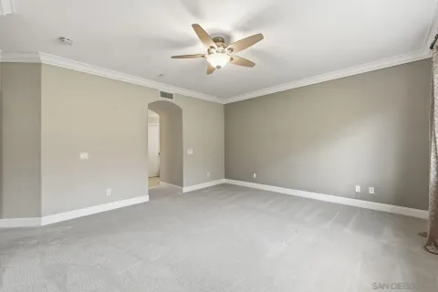 an empty room with closet and ceiling fan