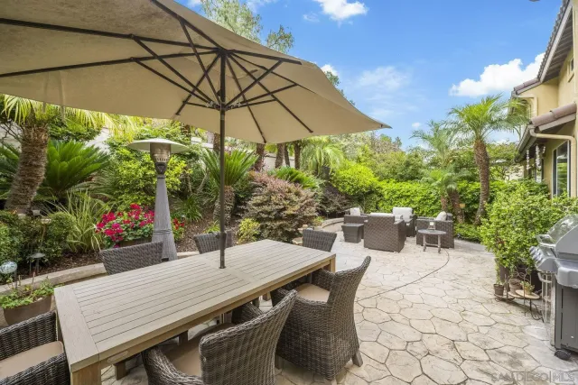 a view of a patio with couches table and chairs and potted plants