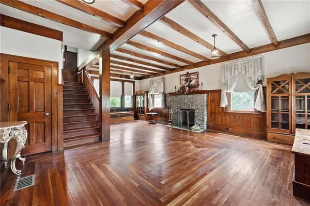 a view of a livingroom with wooden floor and a fireplace
