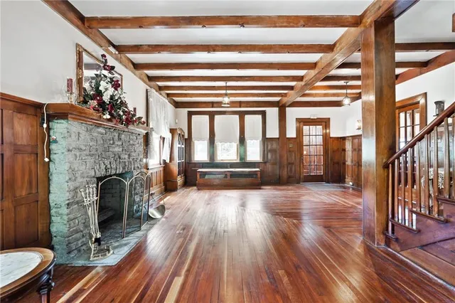 a view of a living room with wooden floor fireplace and a window