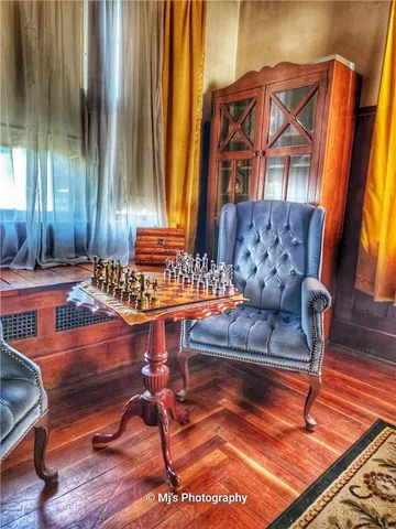 a living room filled with furniture and paintings on the wall