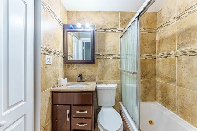 a bathroom with a sink a toilet and shower