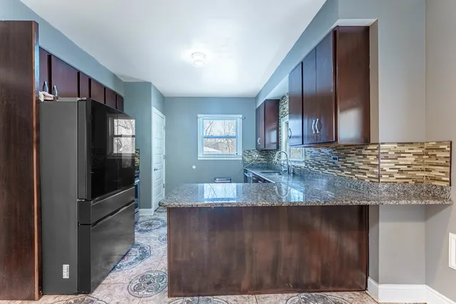 a view of a kitchen with stainless steel appliances granite countertop a refrigerator and a sink