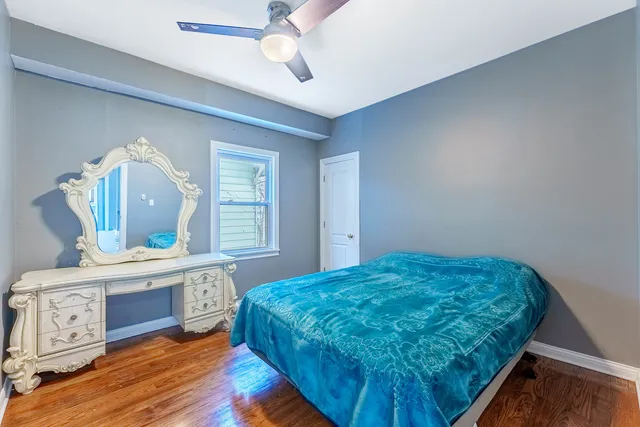 a bedroom with a bed mirror on table and a window